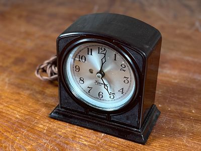 KENMORE, ELECTRIC CLOCK WITH BAKELITE CASE. This vintage Kenmore electric clock features a dark 