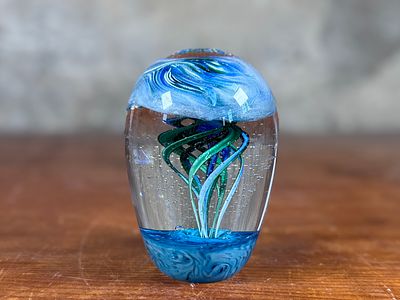 ARTIST SIGNED PAPERWEIGHT. This lot features a beautiful glass paperweight, signed underneath by 