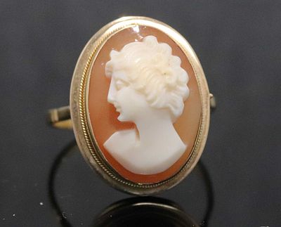 Gold ring with shell cameo, 18 karat. Gold ring with a carved shell cameo in an oval setting of 