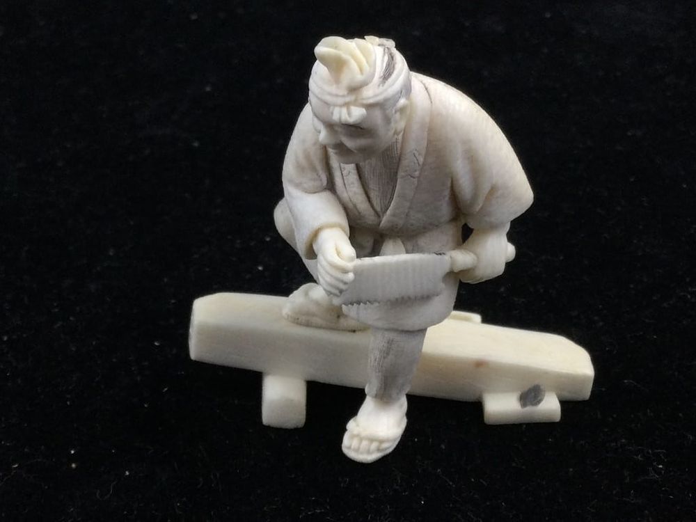 Lot 214: Carved Netsuke Man with Saw