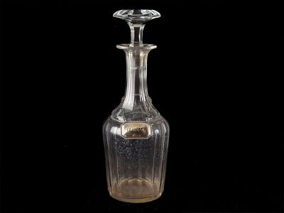 DECANTER. Em vidro moldado e facetado com chapa de suspens&atilde;o em metal prateado com inscri&ccedil;&atilde;o 