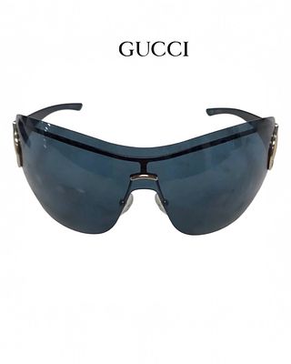 Очки GUCCI с безрамной конструкцией rimless стиле shield с изогнутым силуэтом. Дужки украшены 