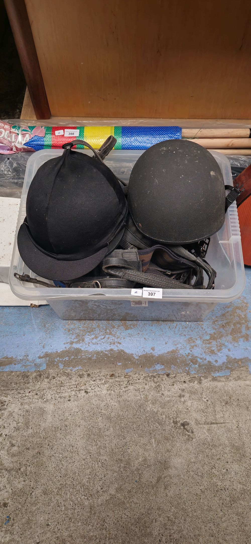 Lot 397: box containing pony tack with helmets