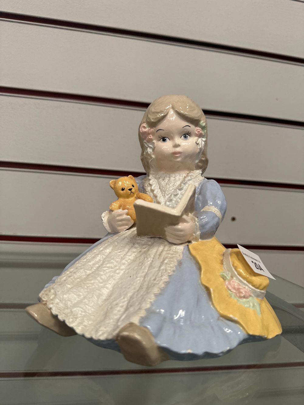 Lot 204: Pottery girl reading book figurine