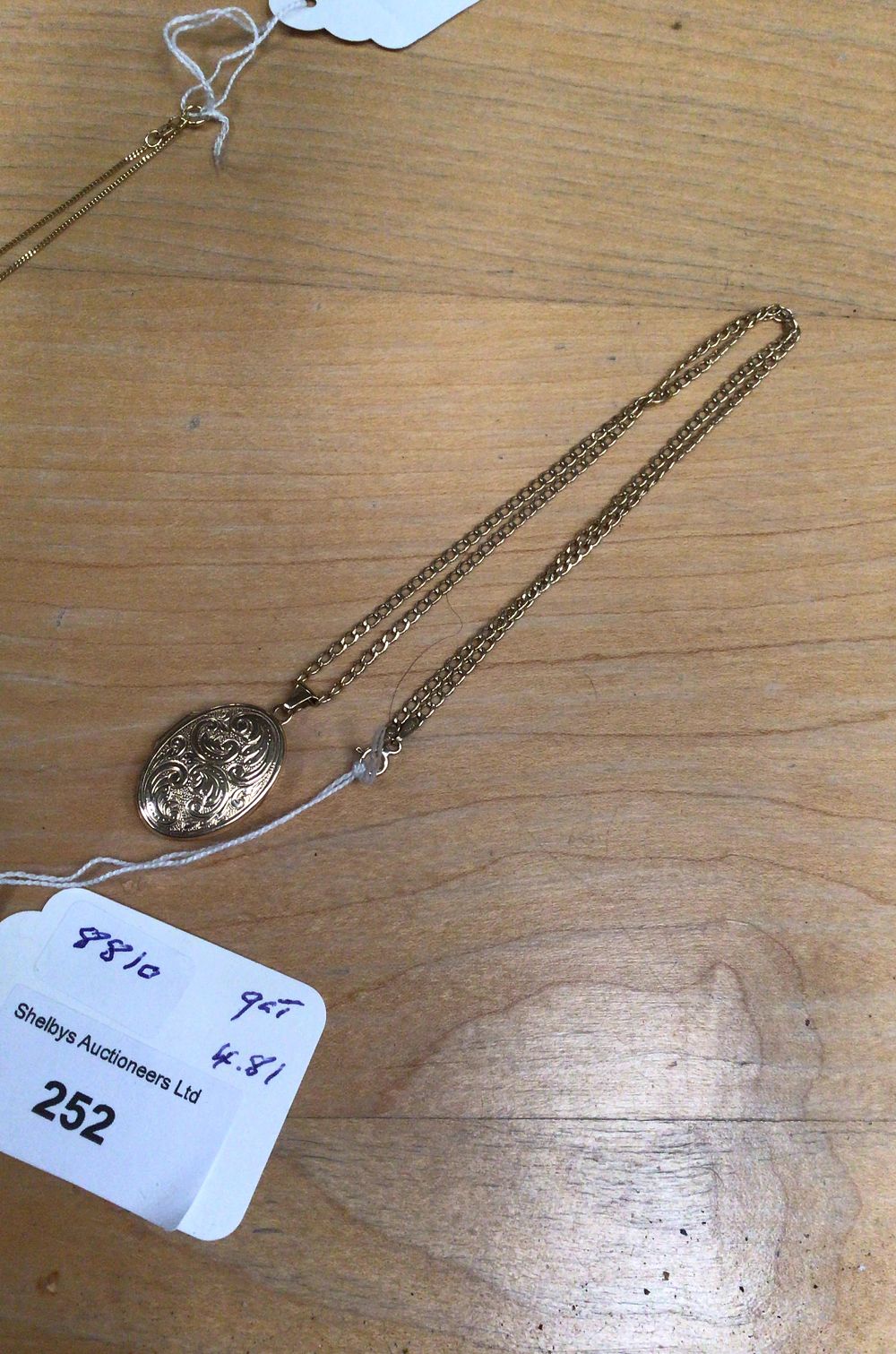 Lot 252: A 9ct Gold Engraved Oval Locket Necklace