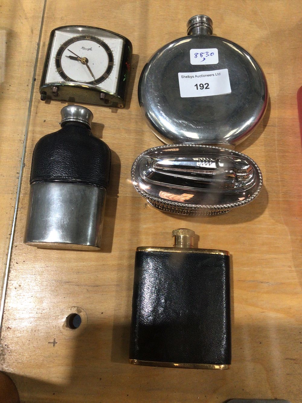 Lot 192: A selection of various hip flasks with clock and table lighter