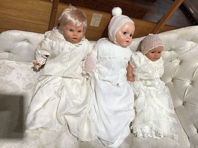 Three Vintage Baby Dolls in White Textile Clothing. A group of three vintage baby dolls, each 