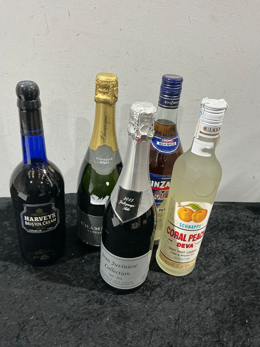 Lot 445: A Collection of 5 Assorted Modern Alcoholic Beverages including Harveys Sherry, Vintage Champagne, and Peach Schnapps