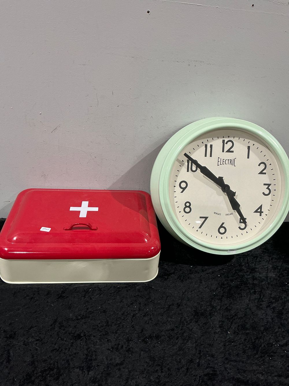 Lot 483: A Pair of Decorative Items including a Newgate Electric Wall Clock and a First Aid Style Storage Tin