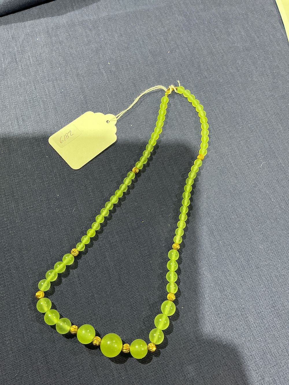 Lot 320: Yellow-tone metal, graduated beaded necklace, yellowish-green beads possibly jade
