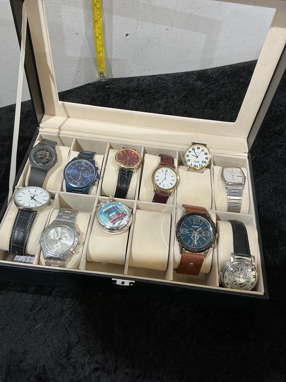 Lot 325: A Collection of Assorted Wristwatches and a Pocket Watch in a Twelve-Slot Display Case