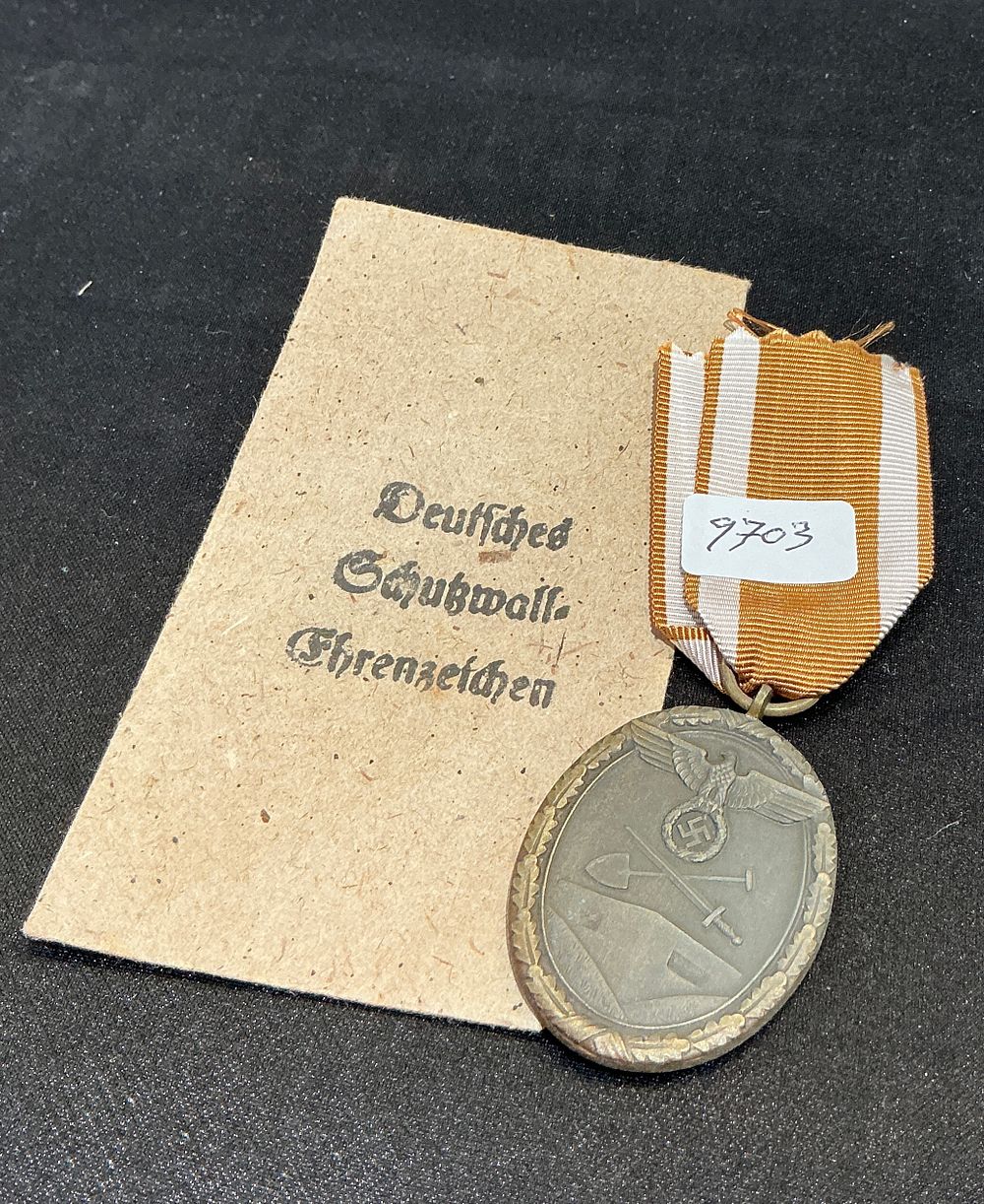 Lot 327: A Second World War German West Wall Medal with Original Ribbon and Packet Fragment