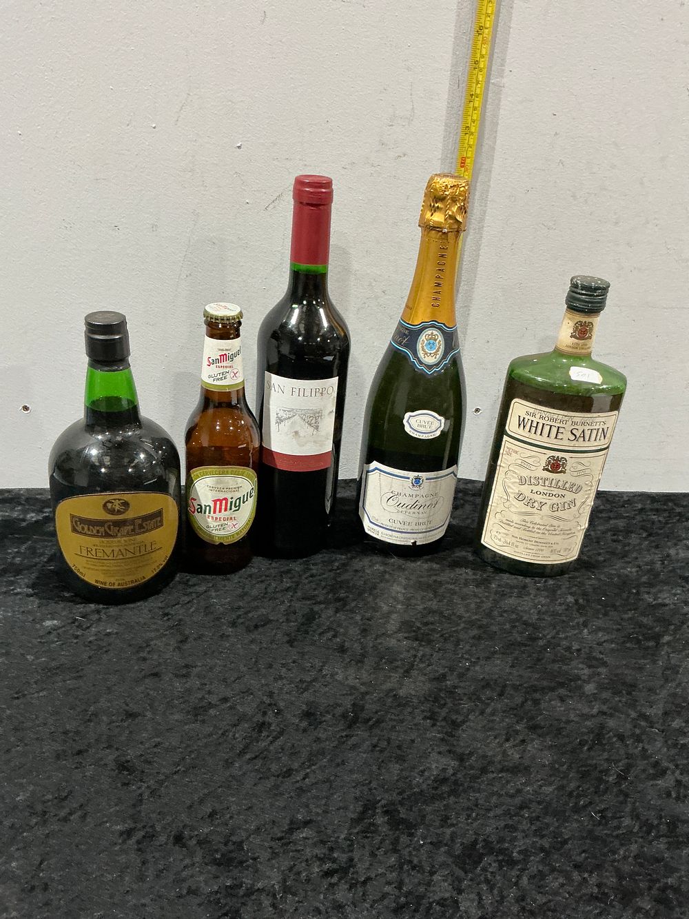 Lot 467: A Selection of Five Bottles of Wines, Spirits and Beer including Sir Robert Burnett’s White Satin Gin and Champagne Oudinot