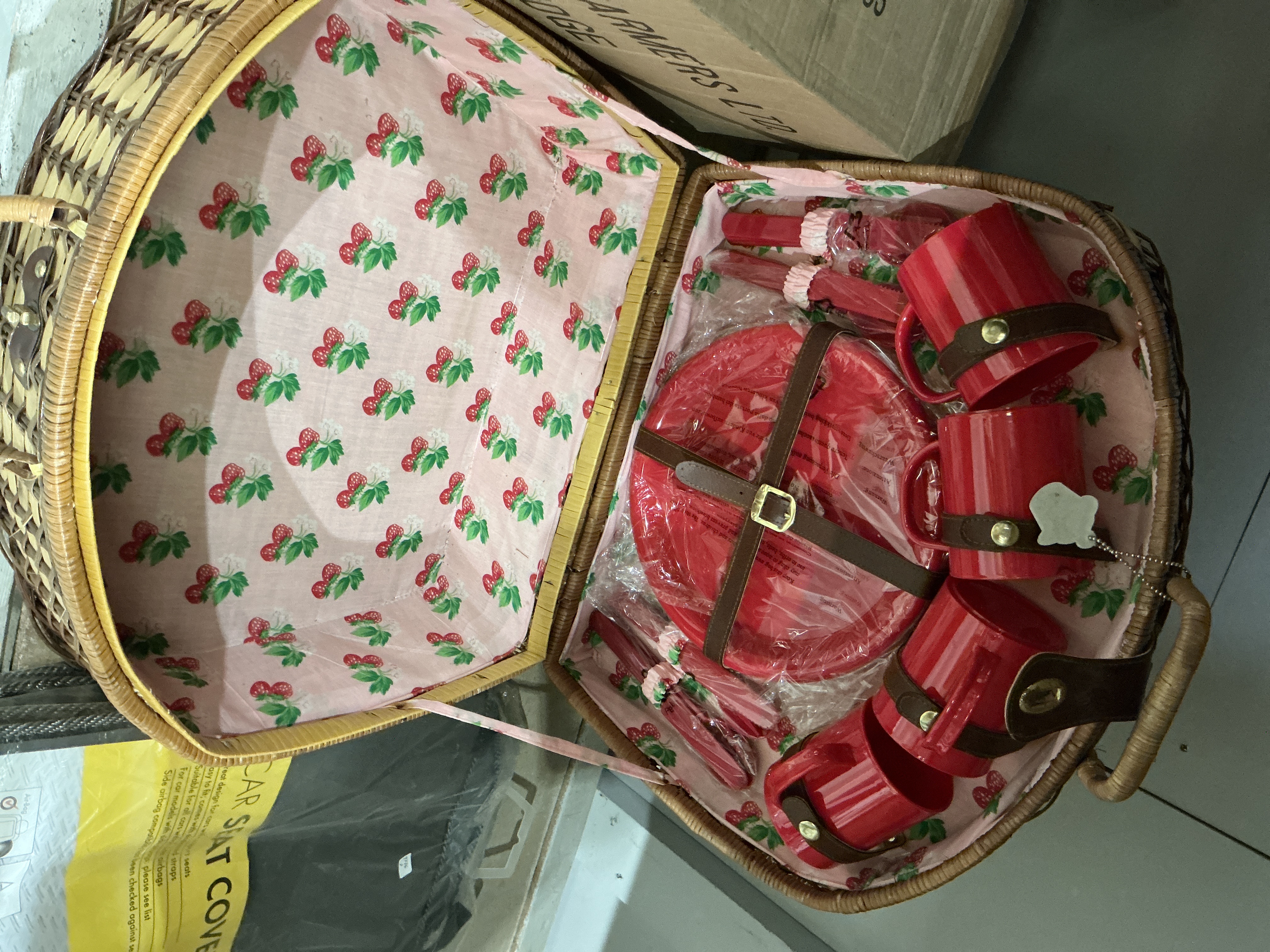 A Set of Red Plastic Picnic Ware in a Wicker Hamper with Strawberry Pattern Lining