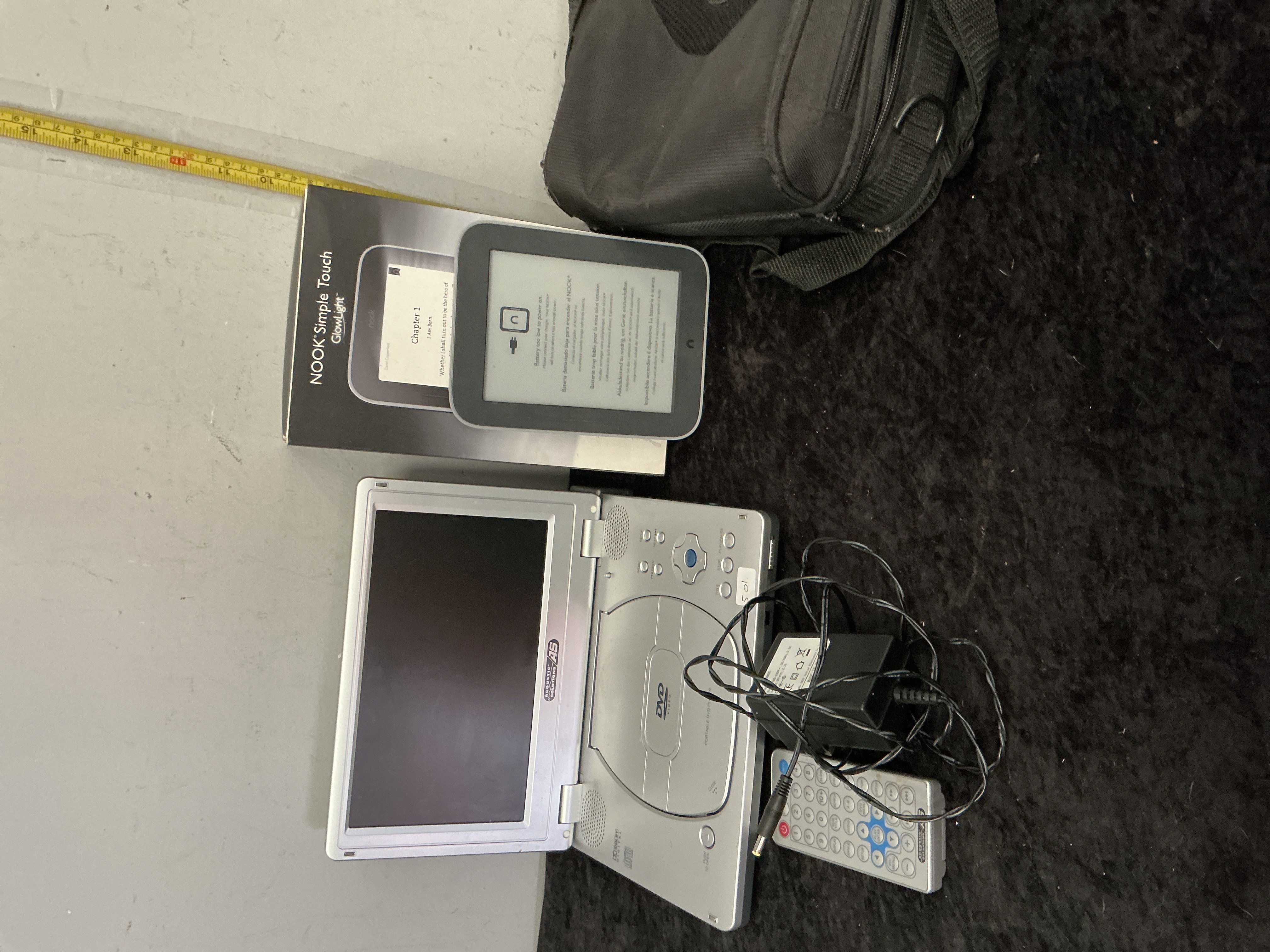 A Group of Portable Electronics comprising Two NOOK Simple Touch with GlowLight eReaders and an Acoustic Solutions Portable DVD Player