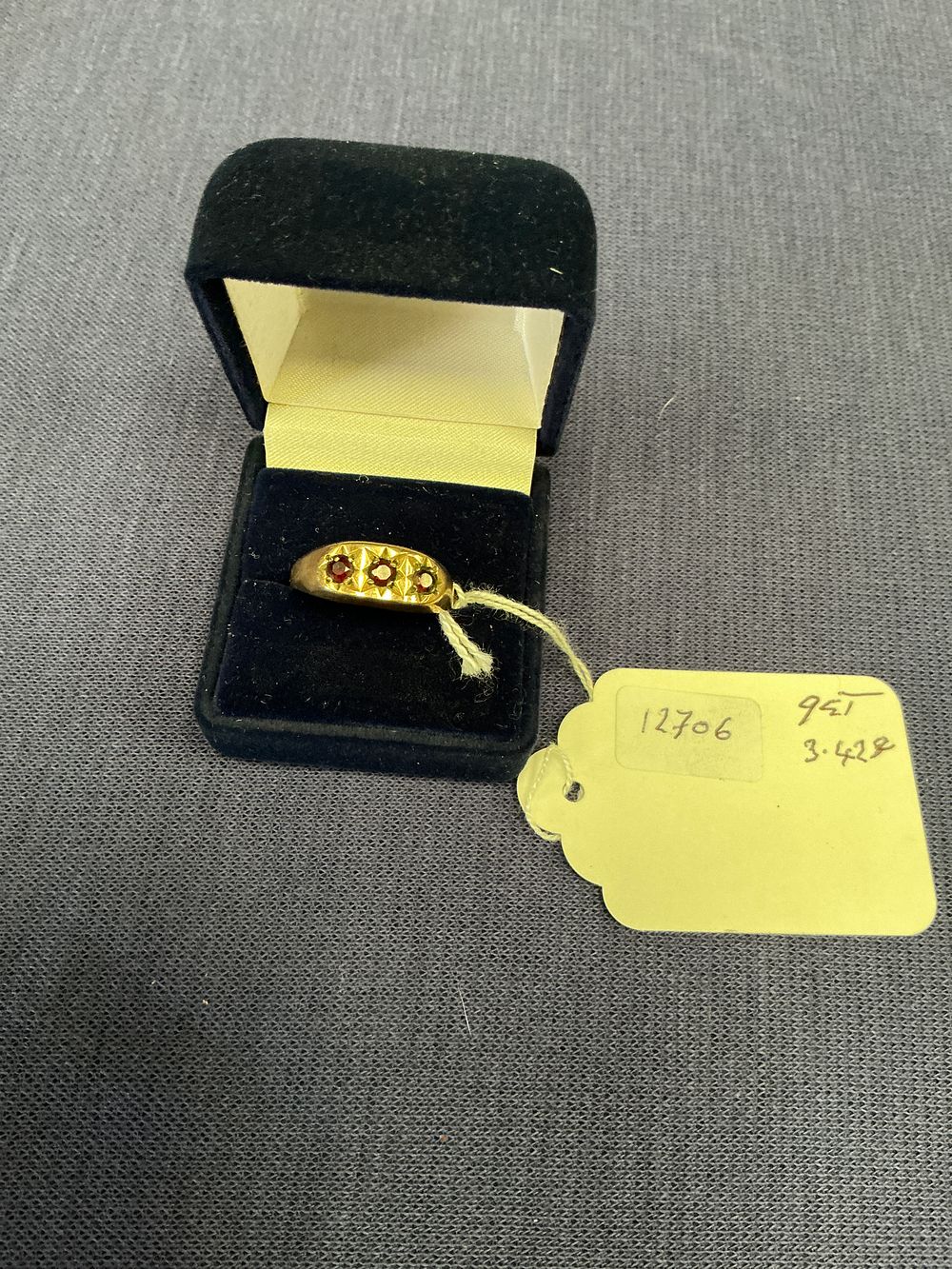 Lot 303: A 9ct Yellow Gold Three-Stone Gypsy-Set Starburst Band Ring