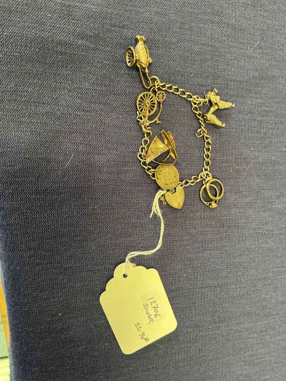 Lot 313: Silver-Gilt Curb Link Charm Bracelet with Seven Charms