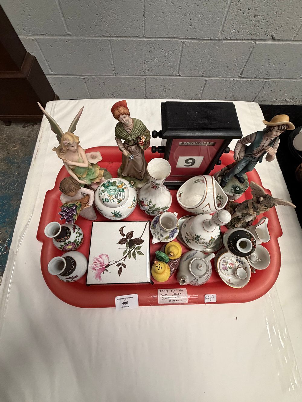Lot 400: A Collection of Porcelain Figurines, Floral Patterned Ceramics, and a Wooden Perpetual Calendar