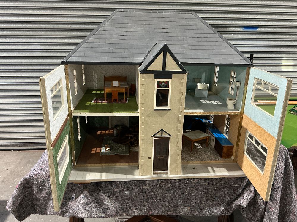 Lot 232: A large mid-20th century suburban style pebbledash dolls house with furniture