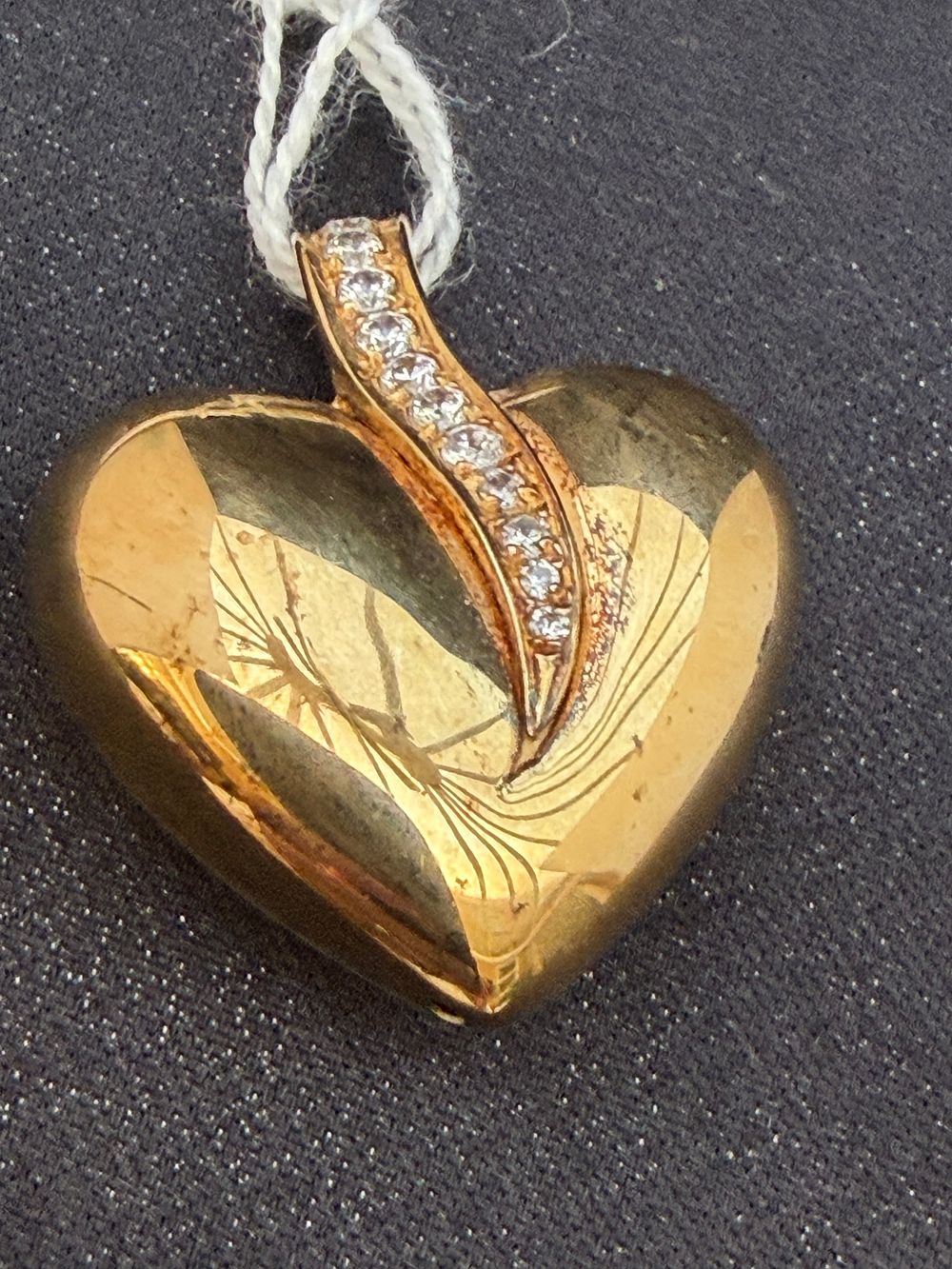 Lot 272: A silver heart-shaped pendant set with nine round-cut clear gemstones