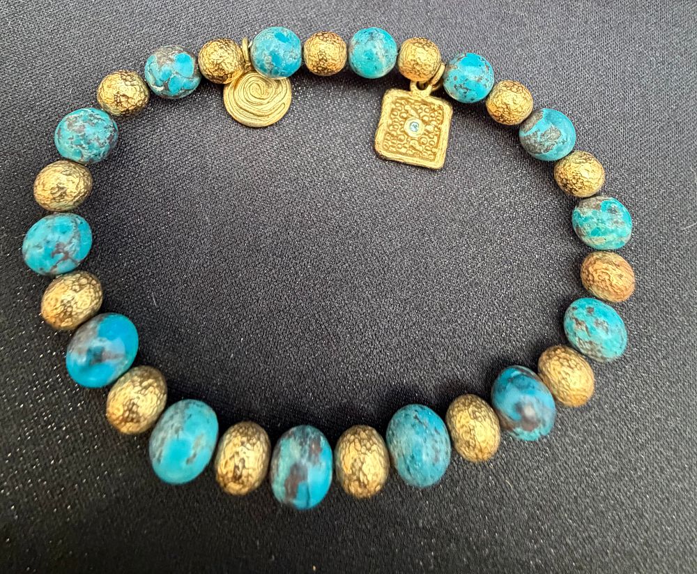 Lot 282: A Silver and Turquoise Beaded Stretch Bracelet with Charms by Etrussa