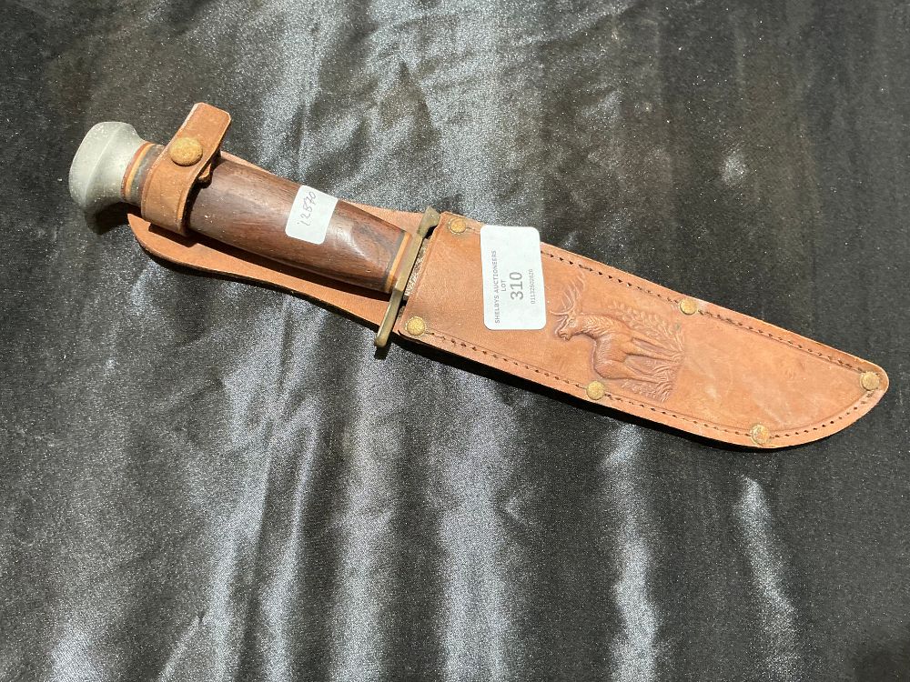 Lot 310: A vintage fixed-blade hunting knife with a dark hardwood handle and a tooled leather stag motif sheath
