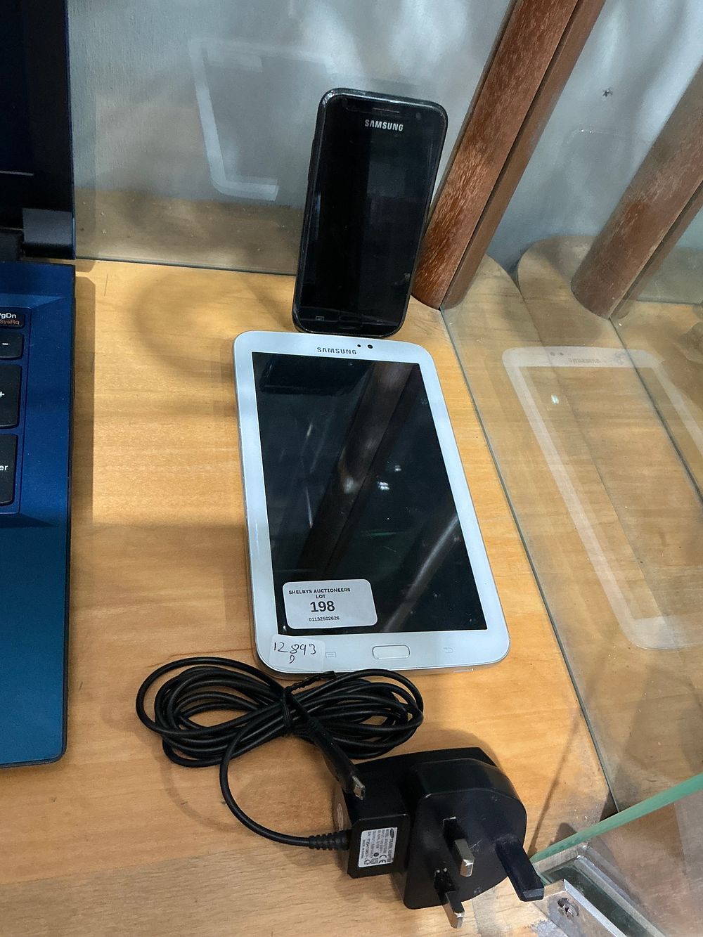 Lot 198: A Group of Samsung Electronic Devices including a Tablet, Smartphone, and Power Adapter