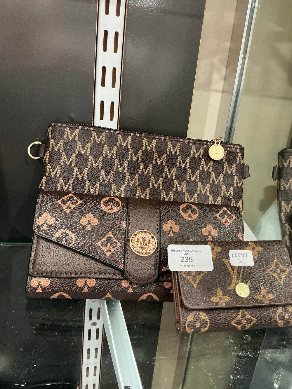 Lot 235: A trio of brown monogrammed fashion accessories comprising two wallets and a handbag