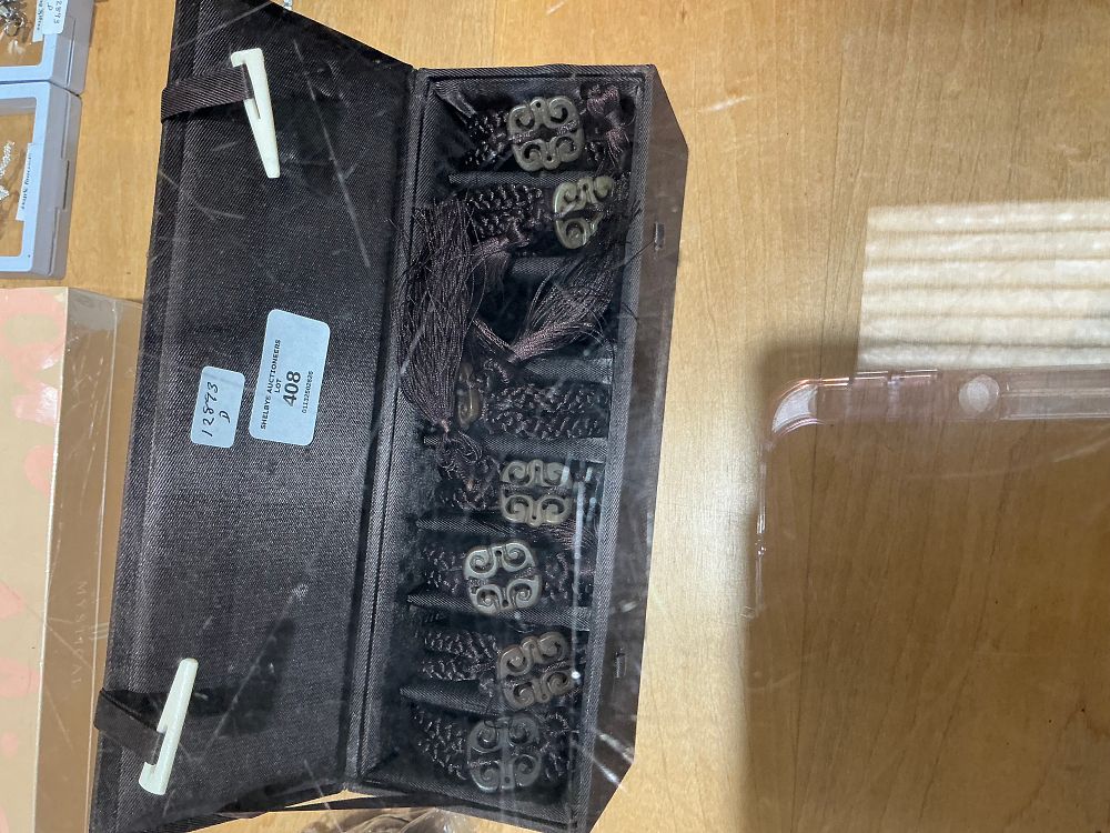 Lot 408: A Collection of Carved Stone and Braided Cord Tassels in a Presentation Case