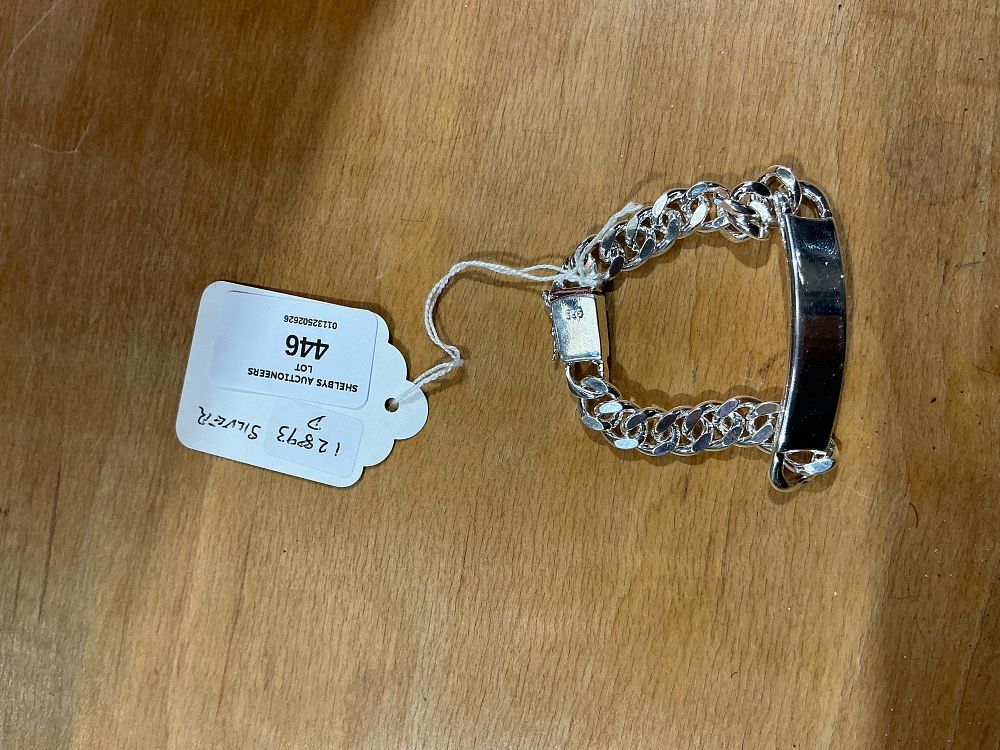 Lot 446: A Sterling Silver Curb Link Identity Bracelet