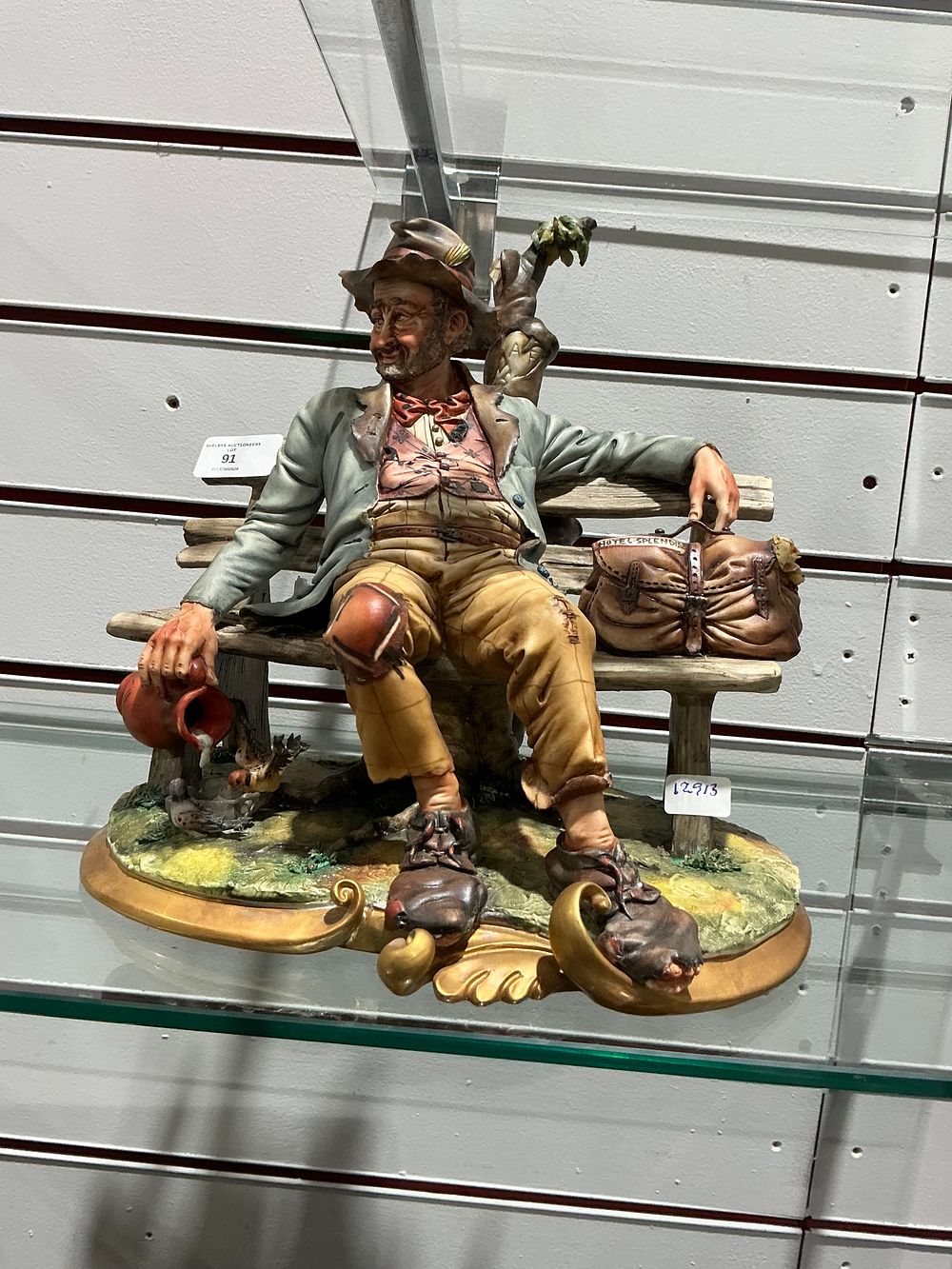Lot 300: Italian style hand painted ceramic figurine of a tramp seated on a wooden bench Capodimonte