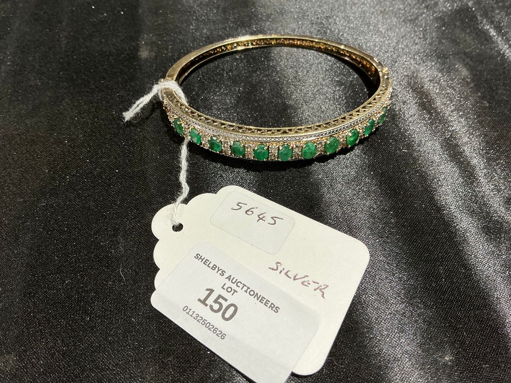 Lot 150: A Silver Gilt Bangle Set with Green Gemstones and Clear Accents 25 grams total weight
