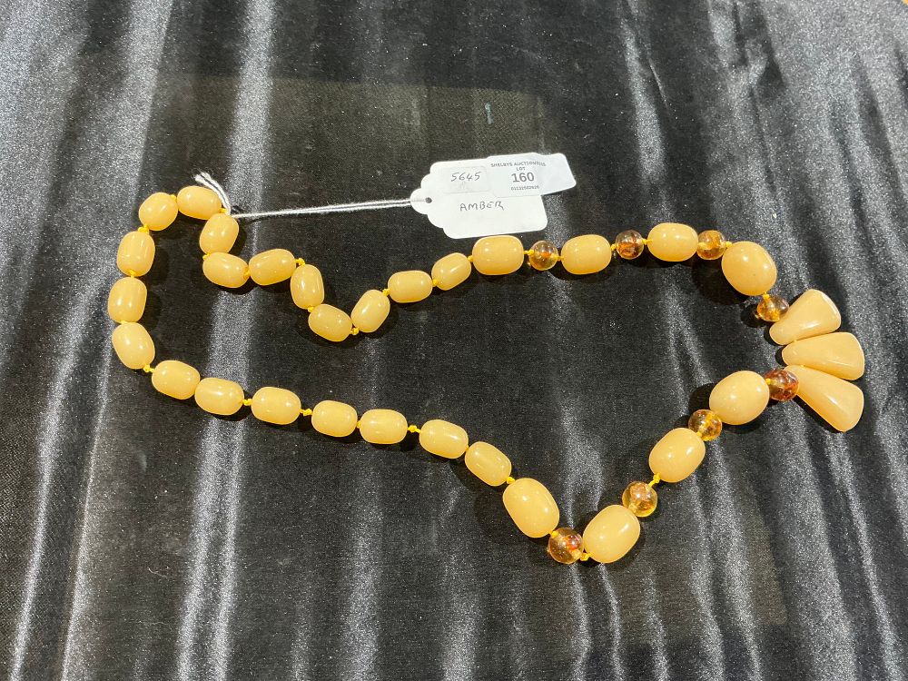 Lot 160: A Vintage Graduated Butterscotch Amber Bead Necklace with Three Bead Pendant Drop