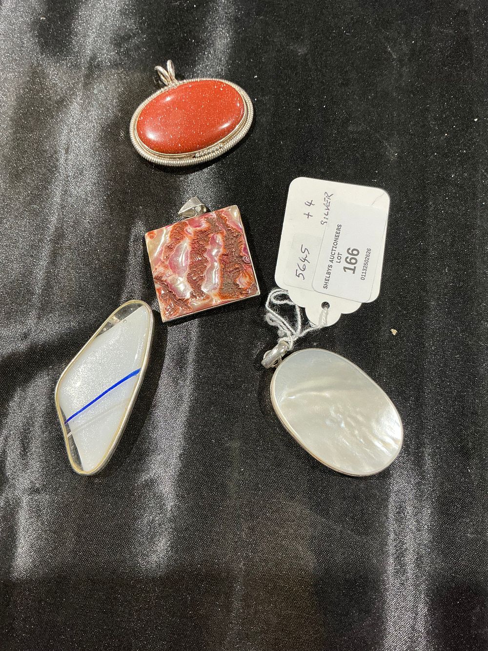 Lot 166: An Assortment of White Metal and Hardstone Pendants