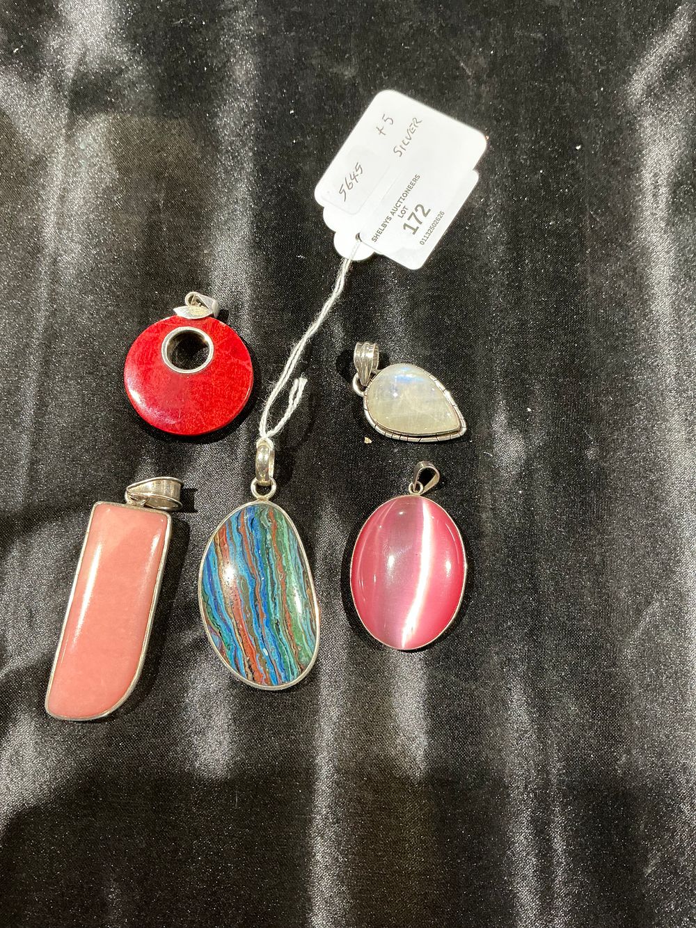 Lot 172: A Group of Five Assorted Polished Stone Pendants in Silver Mounts