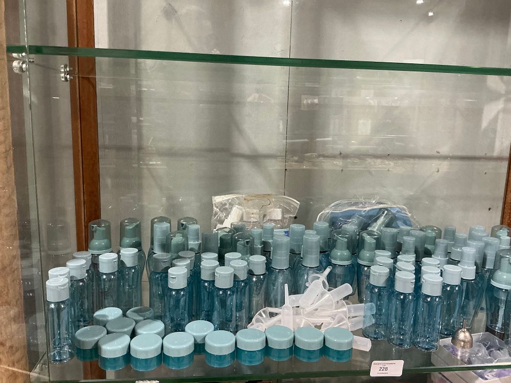 Lot 228: An Assortment of Translucent Blue Plastic Travel Toiletry Containers and Dispensers