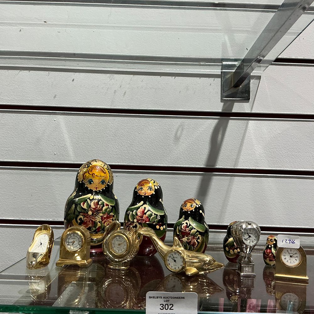 Lot 302: An Assortment of Novelty Miniature Quartz Clocks and Russian Nesting Dolls
