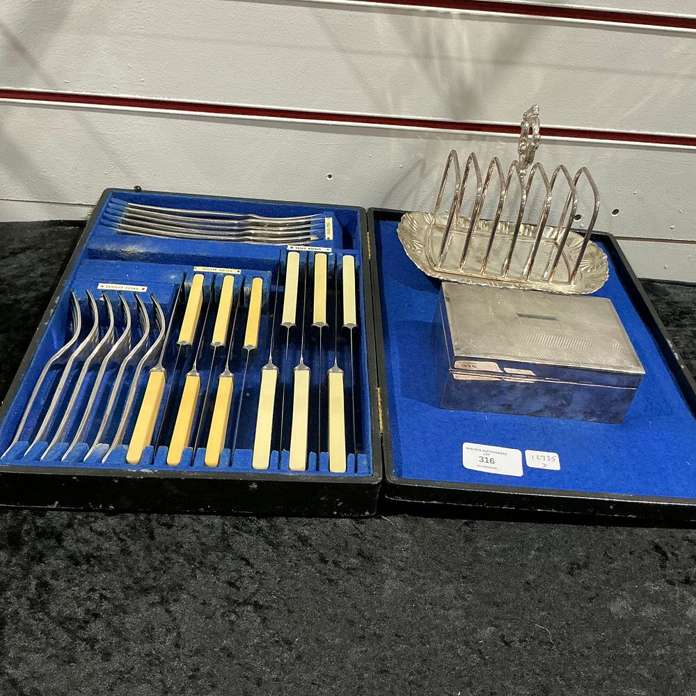 Lot 316: An Assortment of Cased Flatware, a Silver-plated Toast Rack, and an Engine-turned Box