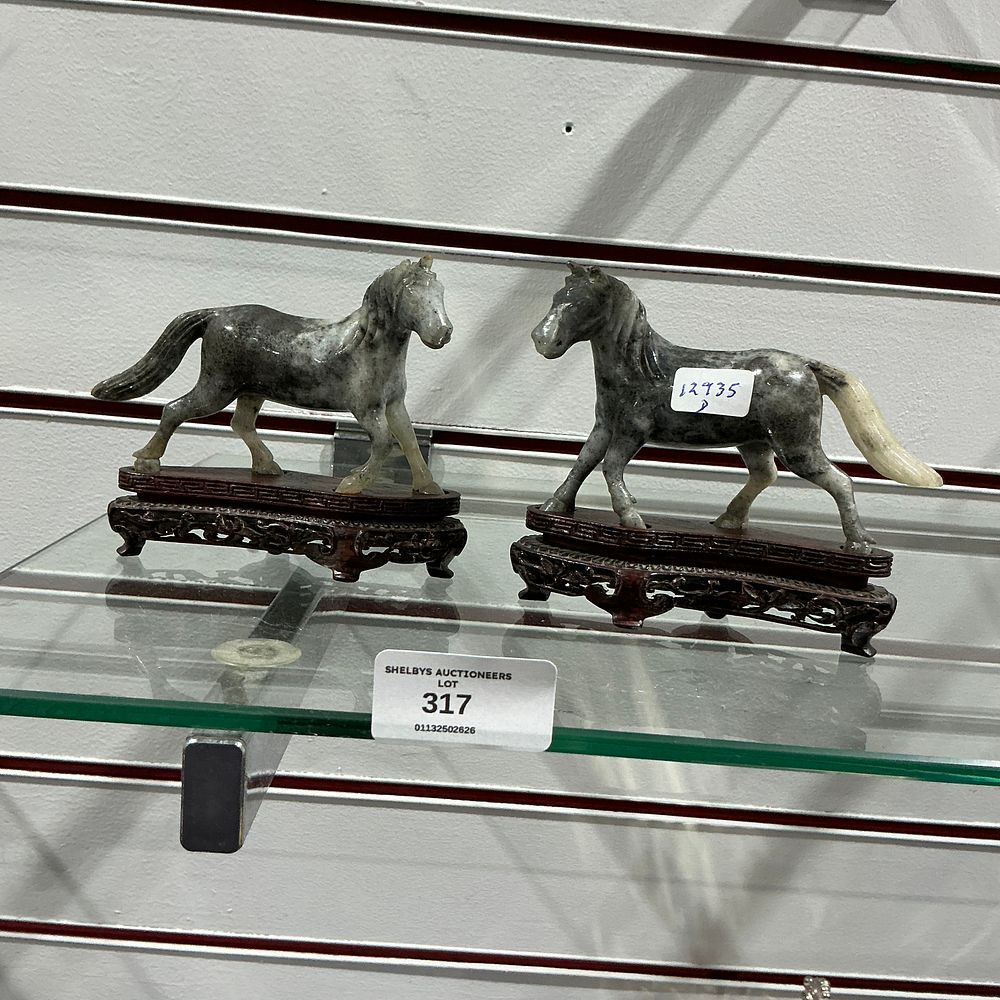 Lot 317: A pair of Chinese grey and white jade horses on carved wood stands