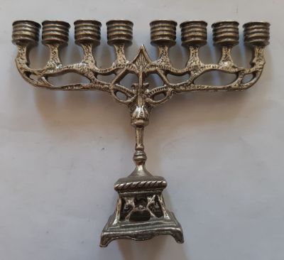 חנוכיה מיניאטורית מכסף. השמש חסר. משקל 35 גרם. גובה 6 ס"מ רוחב כ 7.5 ס"מ הבסיס כ 2 ס"מ.