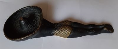 פיגורה מנחושת צבועה לנוי. דמות נערה בחוף ים עם כובע סומבררו. יכול לשמש כמשקולת נייר אולי כמאפרה. 