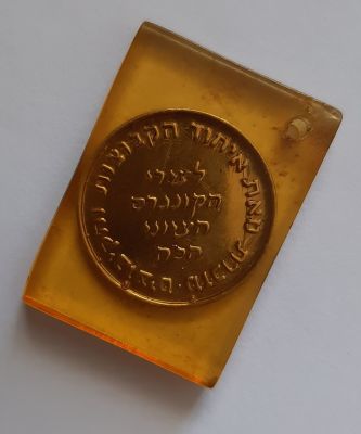 מדליה קטנה מפליז כלואה בפרספקט. הענקה של אחוד הקיבוצים לרגל 