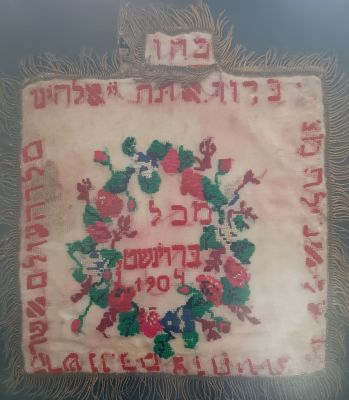 כיסוי עתיק למצות לפסח מבד עם רקמה משנת 1904. נתון במסגרת. לשוניות כהן , לוי, ישראל. פגמים קלים 