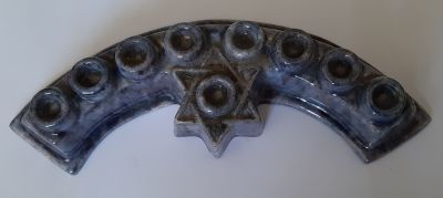 חנוכייה קרמיקה ישנה לא שכיחה בצורה קשתית עם מגן דוד בצבעים מרהיבים. אורך 22 ס"מ. פגם זעיר 