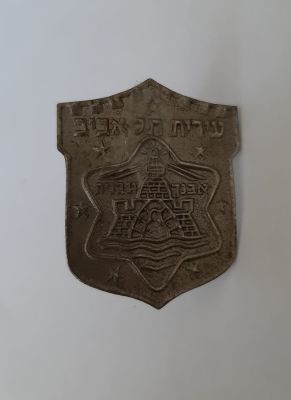 סמל כובע ישן של עירית תל אביב . גודל מירבי 3X3.8 ס"מ.