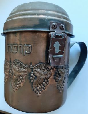 קופת צדקה מנחושת, ישנה עם מכסה ונעילה. גובה כ 15 ס"מ. 