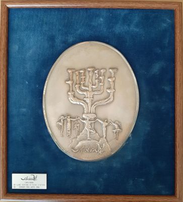 מודליה אובלית "רוקדים סביב המנורה" של האמן סלבדור דאלי נתונה במסגרת. האמן חתום בתבליט. הנפקת 