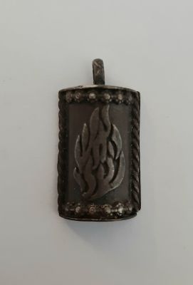 תליון כסף ישן עם חלל פנימי (לא הצלחנו לפתוח, אולי יש בתוכו קמע). מאחור על גב התיליון סימני קמע 