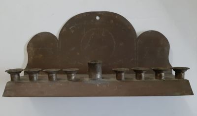 חנוכיה ישנה סביבות 1950 עבודת יד מנחושת. על גב החנוכיה כתוב "מדן ועד אילת - מדינת ישראל" וציור 