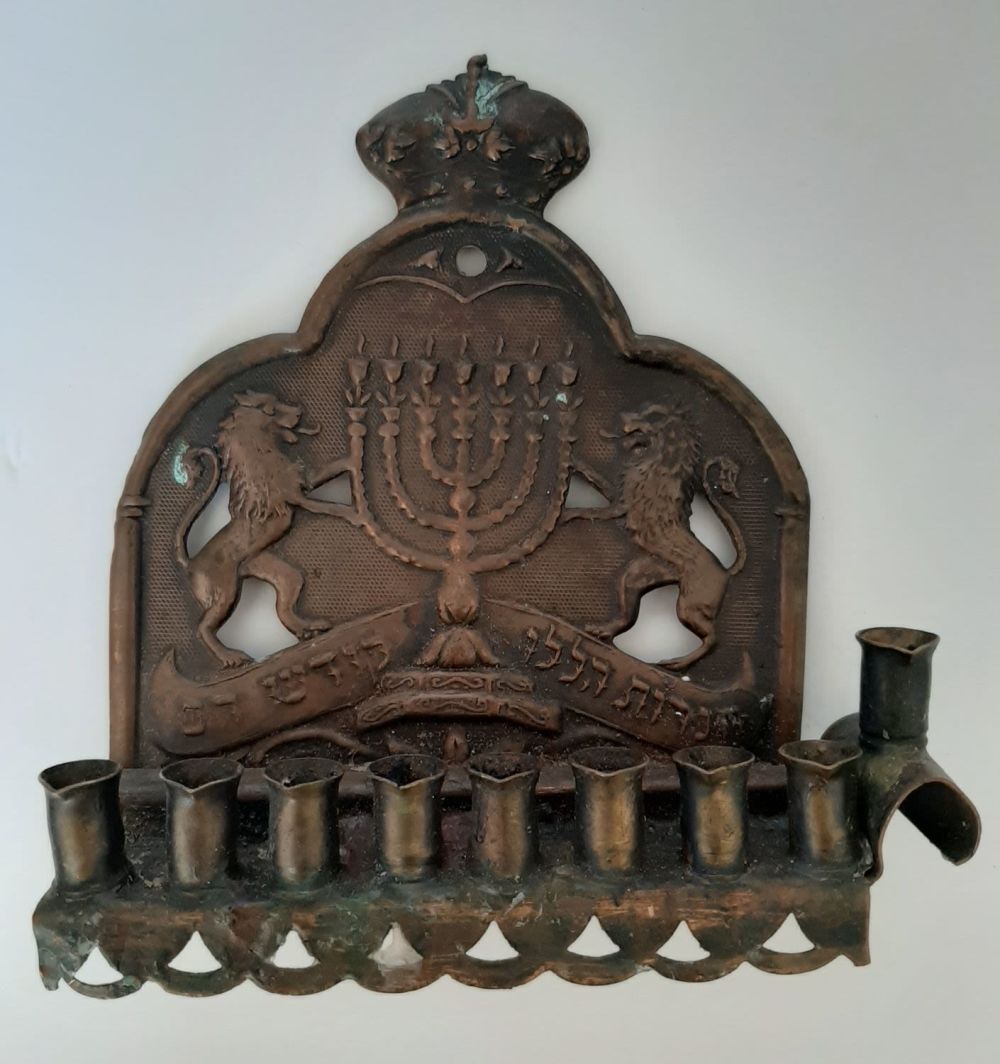 חנוכיה נחושת ישנה ולא מצויה. גב דוגמא אריות וכתר.